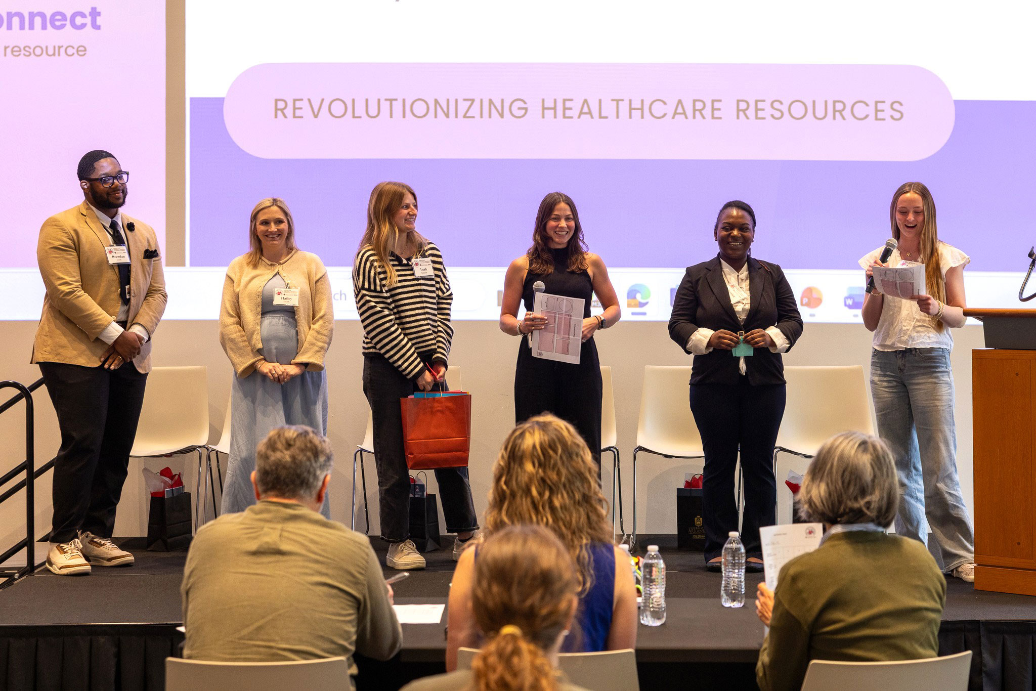 Innovate for Healthcare and Education team shares their presentation at the front of the room.