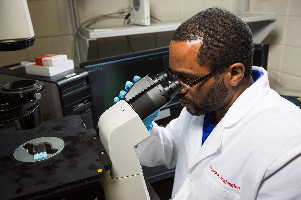 Man looking into microscope